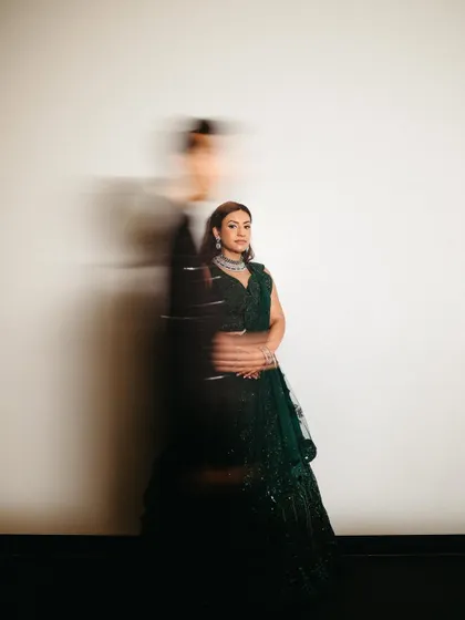 An artistic motion-blur portrait of the bride, with the groom as a passing silhouette, creating a sense of fleeting, beautiful moments.