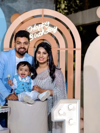 A sweet family portrait at a modern, chic first birthday party with a teddy bear and rainbow theme.