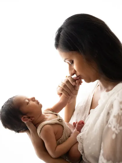 A mother gently kissing her newborn's tiny hand. It's these little gestures of love that I adore capturing.