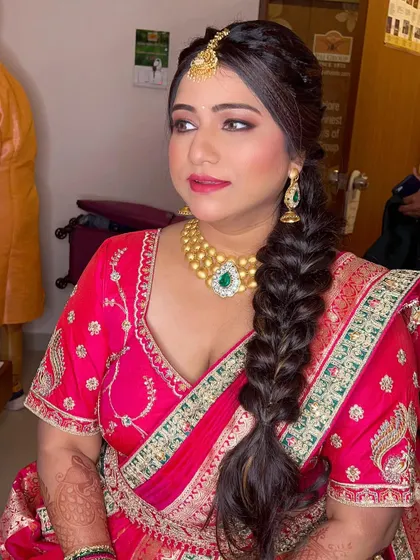 This bride-to-be is glowing for her ring ceremony. We created a glamorous look with smokey eyes and a pink lip to go with her stunning pink lehenga saree.