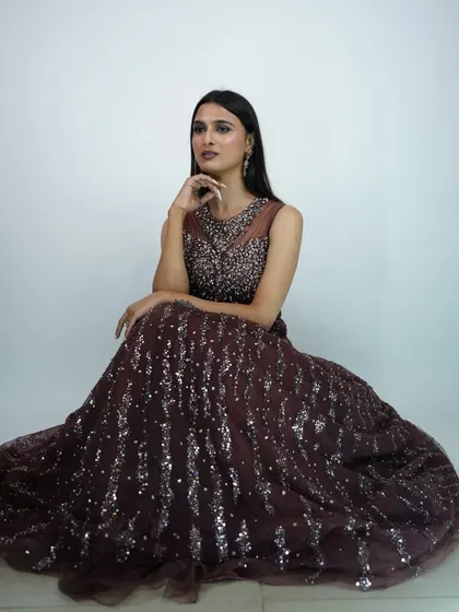 This deep brown sequined gown is a unique and elegant choice for an evening reception. The illusion neckline adds a touch of modern sophistication.