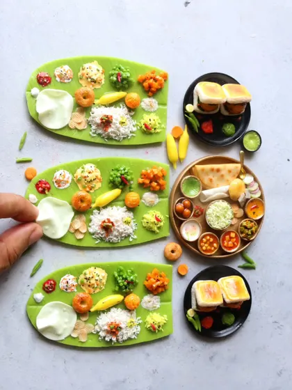 A beautiful arrangement of banana leaf meals, a North Indian thali, and vada pav miniatures.