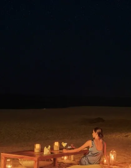 A romantic beach dinner setup under a starry sky at The Postcard Arabian Sea, perfect for an intimate and unforgettable evening.