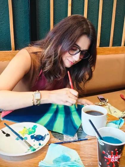 Deep in concentration, a participant paints the glowing sky. Our workshops provide a space to unwind and focus on creativity.