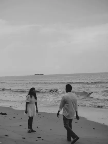 A wide, atmospheric beach scene in black and white. This composition feels cinematic and timeless, turning a simple walk on the beach into a piece of art.