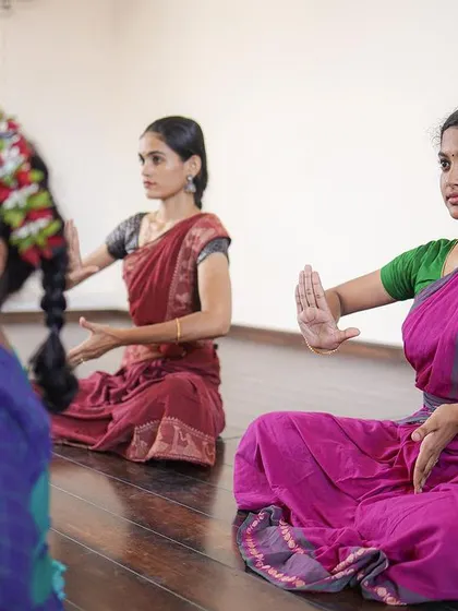 Students seated for a lesson on abhinaya or hand gestures. The wooden floor is comfortable for floorwork and seated choreography.