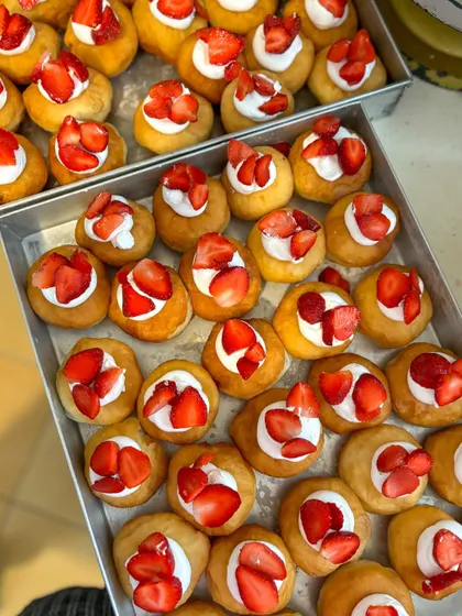 Trays of fresh strawberry and cream bombolinis getting ready for a birthday celebration.
