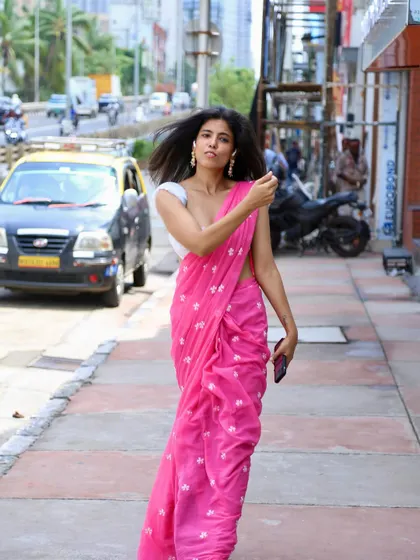 A candid, windswept look while modeling a pink saree on a busy street, showing my ability to work with natural elements to create an effortless shot.