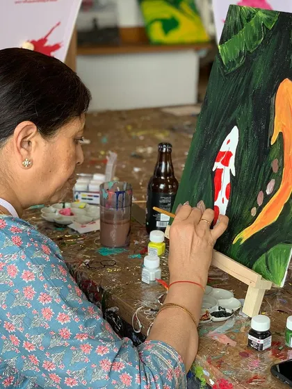 A painter working on a beautiful koi fish painting. This theme is a favorite, allowing for beautiful color blending and graceful compositions.