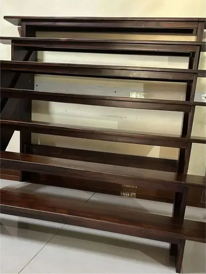 The custom-made Golu stand, shown here in its raw form. It is a collapsible, multi-tiered wooden structure designed specifically for the traditional South Indian display of dolls during Navaratri.