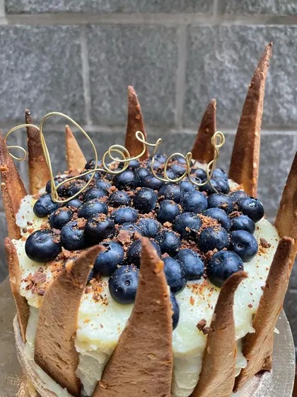I love how the golden wire topper looks against the deep blue of the berries on this custom pet-friendly cake.