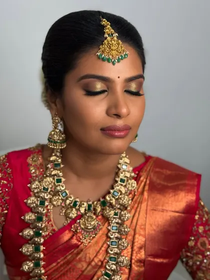 A close-up of Abi's eye makeup. The golden shimmer on her lids and the sharp winged liner make her eyes the focal point of this glamorous traditional look.