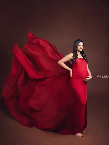 A full-length portrait against a warm brown backdrop, where the flowing red fabric provides a beautiful contrast.