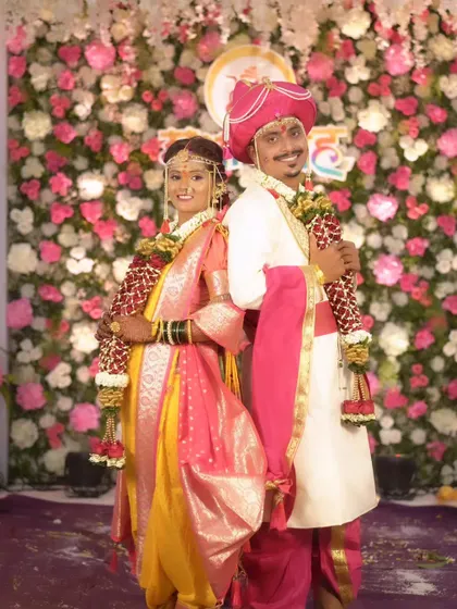 A classic back-to-back pose of the bride and groom in their traditional Maharashtrian wedding attire.