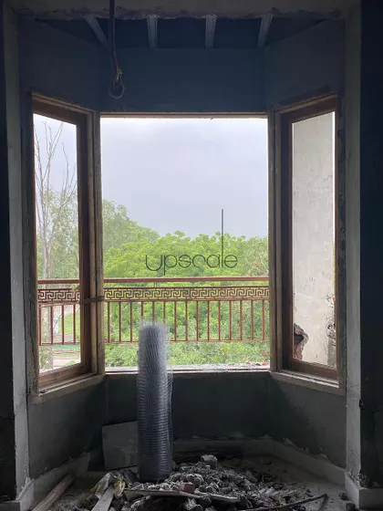 A view from a bay window on a construction site. Even in its raw state, the potential of the space is clear, framing the lush greenery outside and promising a beautiful, light filled corner.