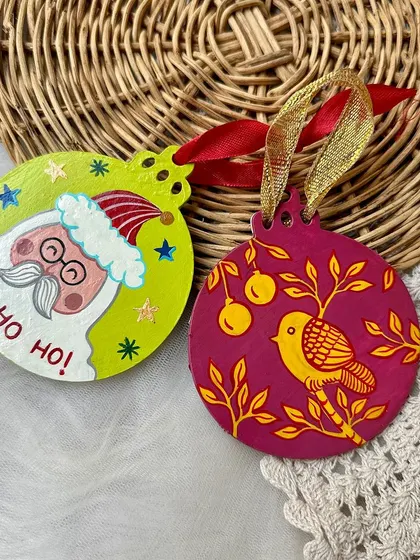 A cute Santa Claus and a partridge-in-a-pear-tree themed wooden Christmas ornament.