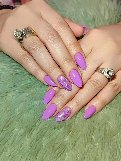 This set combines a solid purple polish with a shattered glass effect on the accent nails. We teach you how to use foils and other materials to create unique textures and finishes.