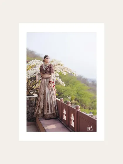 A bride posing against a backdrop of white flowers, her portrait framed in white.