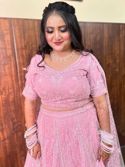 A beautiful bride in a baby pink chikankari lehenga, her makeup soft and romantic to match.
