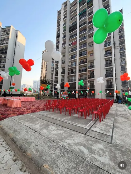 The outdoor event area decorated for Independence Day celebrations, with tricolor balloon clusters floating above the seating arrangement.