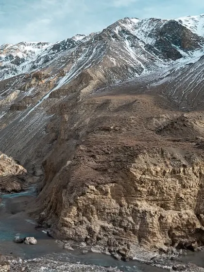 A collection of breathtaking landscapes from Spiti. These images feature the majestic snow-capped peaks, the turquoise river, and the dramatic, winding roads carved into the mountainside.