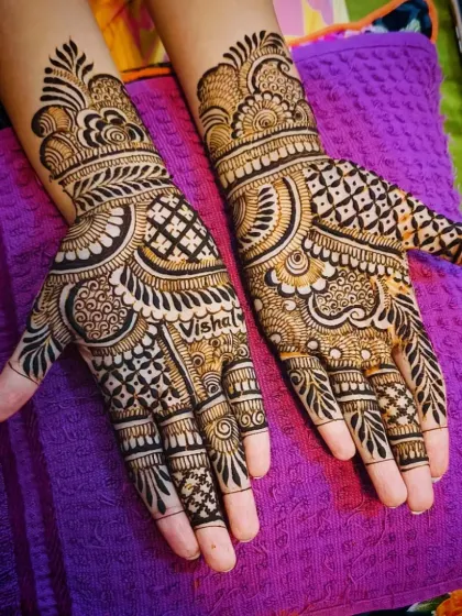 An angled shot of the 'Vishal' mehandi, showing the design flow onto the wrist.