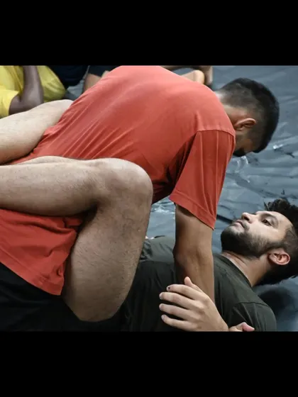 Two students engaged in a BJJ roll, working to pass the guard. This is the "physical chess" aspect of jiu-jitsu.