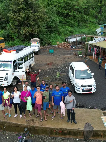 Waving goodbye as we wrap up another successful trip. The vehicles that carried us through the adventure are in the background.