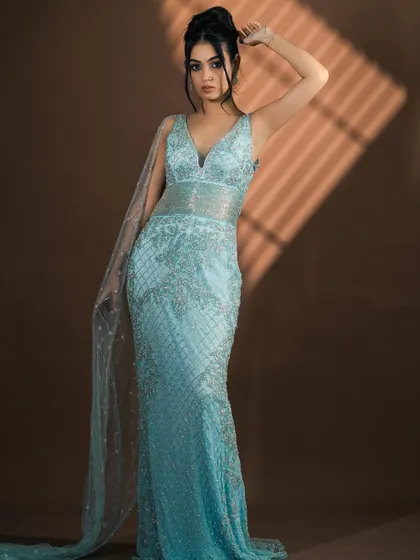 Another angle of the light blue gown, showing how the light plays off the sequins against the rich brown studio background.