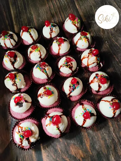 A fun and playful design that looks just like a tiny ice cream sundae. Each cupcake is topped with a scoop of buttercream, chocolate drizzle, rainbow sprinkles, and a cherry on top.