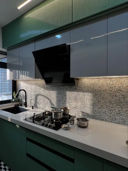 A closer look at the glossy cabinets and the detailed backsplash, showcasing the quality of materials and finishes.