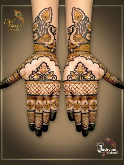 A simple yet elegant symmetrical design with peacocks on the wrists and lotus motifs on the palms. The finger details add a touch of royalty.