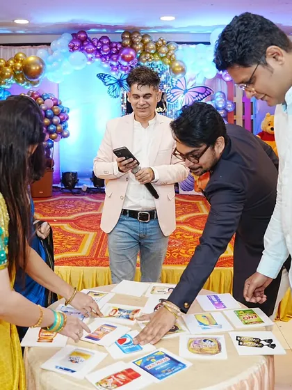 Guests participating in a brand logo guessing game at a baby shower. I bring a variety of games to entertain guests of all ages.