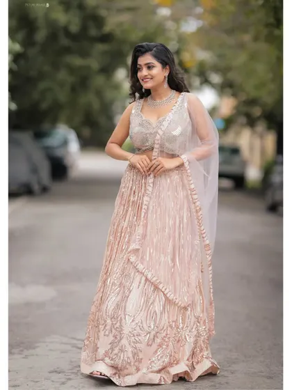 This full-length shot of the rose gold sequin lehenga shows how it catches the light, making you the center of attention at any event.