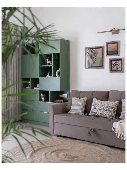 Another view of the study's green storage unit and sofa-bed, creating a cozy and functional corner. A round jute rug anchors the space, adding to the room's warm, earthy feel.
