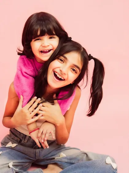 The pure, unfiltered joy of sisterhood. This studio kids photoshoot was all about capturing their vibrant energy and laughter against a simple, bright pink backdrop that lets their personalities shine.