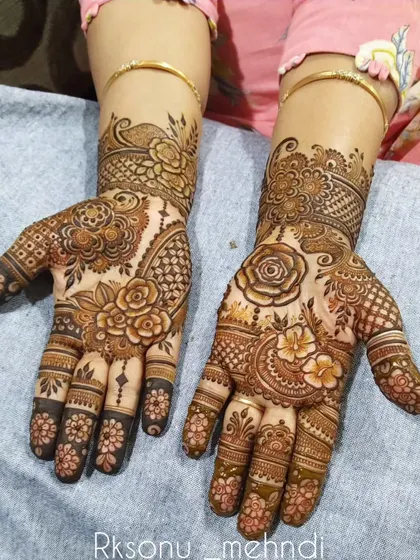 A classic Indian design that blends bold floral motifs with contemporary patterns. The dark fingertips provide a traditional contrast to the intricate work on the palms and wrists.