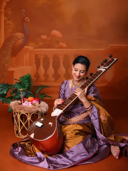 Incorporating personal passions into the shoot. Here, the mom-to-be, dressed in a traditional saree, holds a sitar, blending her love for music with her maternity journey.