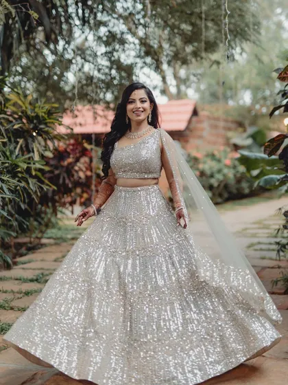 A joyful shot of the bride, Ashwini, twirling and smiling in her reception outfit.