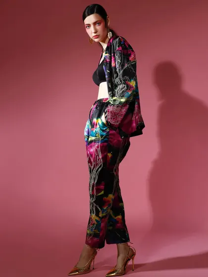 A side profile of a model in a printed co-ord set, worn as a jacket over a simple black bralette. This styling choice gives the look a relaxed yet chic edge.