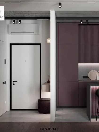The entryway view reveals the striking plum kitchen, framed by a white partition that creates a sense of discovery and architectural interest.