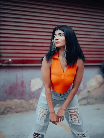 A full-length shot of a model in a casual outfit against an urban background. The composition is dynamic and perfect for a street style lookbook.