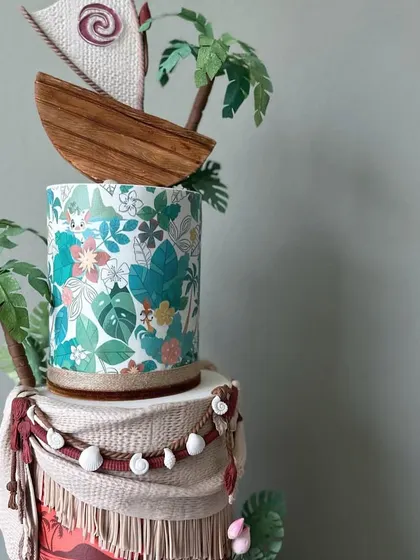 The top tier of the Moana cake, featuring the hand-modeled boat and sail.