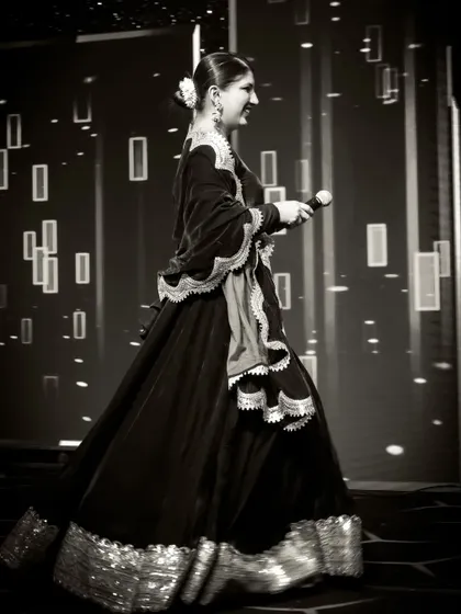 A classic black and white photo, capturing my movement and the flow of my traditional dress as I walk across the stage.