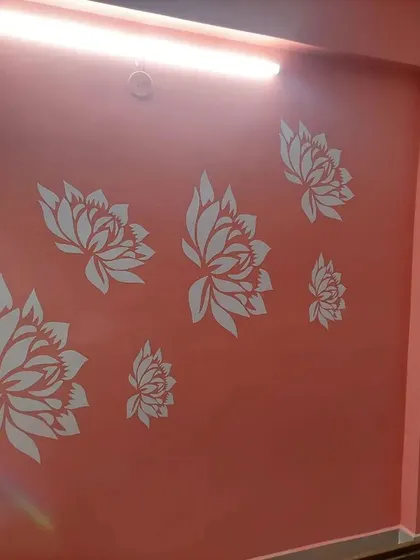 A beautiful arrangement of white lotus flower stencils on a calming coral-pink wall, creating a serene and decorative floral feature.