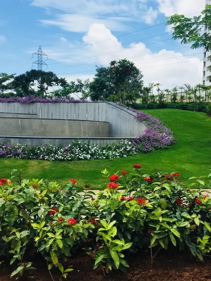 A beautiful display of landscape architecture, with tiered retaining walls covered in flowering plants, adding dimension and color to the community space.