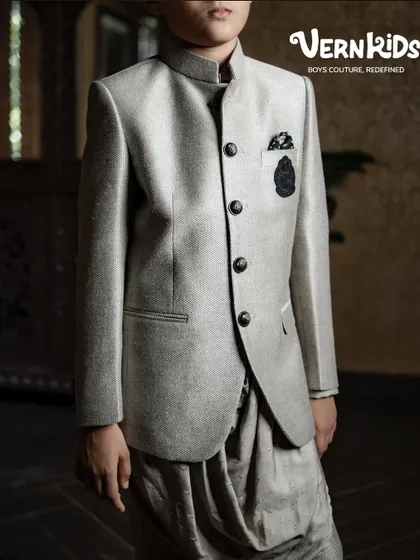 A close-up of our grey Jodhpuri jacket paired with a dhoti-style pant. This angle highlights the unique silhouette and texture of the fabric, a perfect blend of tradition and trend.
