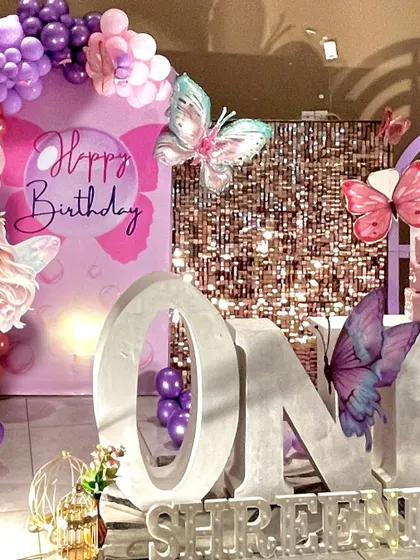 A detailed shot of the 'ONE' marquee letters and the sparkling sequin backdrop from the butterfly-themed party.