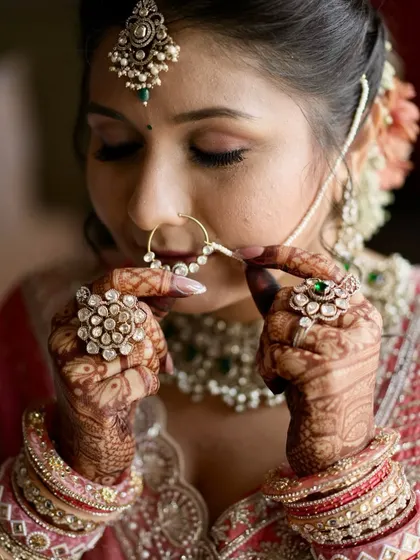 It's all in the details. This artistic shot captures the delicate balance of soft glam makeup, intricate henna, and traditional jewelry, creating a look that is both timeless and personal. ✨
