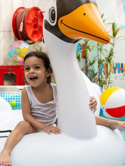 Riding a giant swan float is one of the many fun highlights of our pool parties.